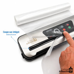 Vacuum sealer with built-in bag cutter and roll of plastic film; hand operating the seal.