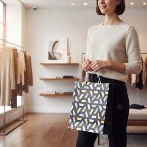 Woman in a light sweater and black pants holding a geometric patterned shopping bag in a clothing store. A rack of clothes is visible in the background.