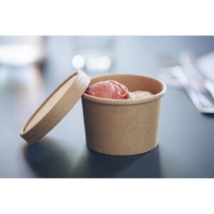 Brauner Pappbecher für Eiscreme mit einer rosa und einer gelben Kugel, der Deckel liegt daneben auf einer dunklen Oberfläche.
