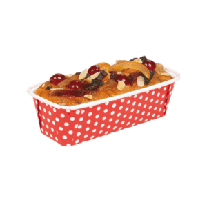Fruitcake loaf topped with dried fruits in a red polka-dot paper baking cup.
