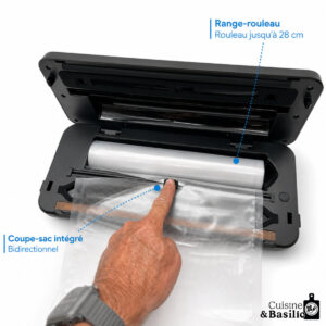 Person places a plastic bag into an open vacuum sealer, with blue guide lines highlighting the bidirectional cutter and bag length up to 28 cm; Cuisine & Basilic branding visible.